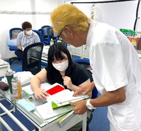 長澤代表が生徒に寄り添って指導する様子